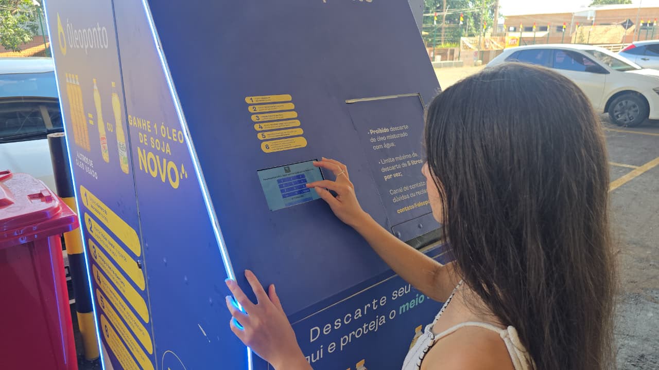 Usuária interagindo com o painel da estação Óleoponto